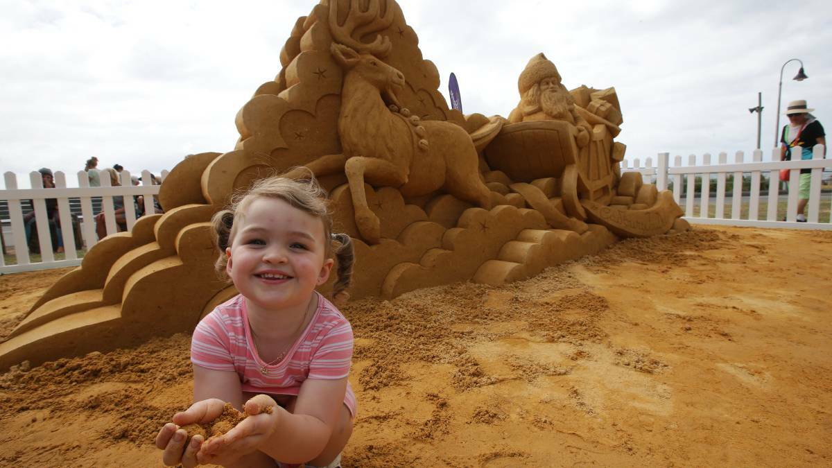 Creation: Ava Pepper, 3, enjoys the sand sculpture in Cronulla. Picture: John Veage