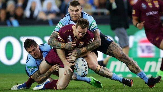 Solid defence: Michael Morgan of the Maroons drops the ball in a tackle by Mitchell Pearce and Josh Dugan. 