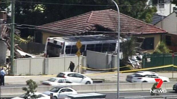 Two women and a man were hurt after an empty bus ran up the curb and crashed into houses in Sydney's north-west on Saturday.  Photo: Seven News