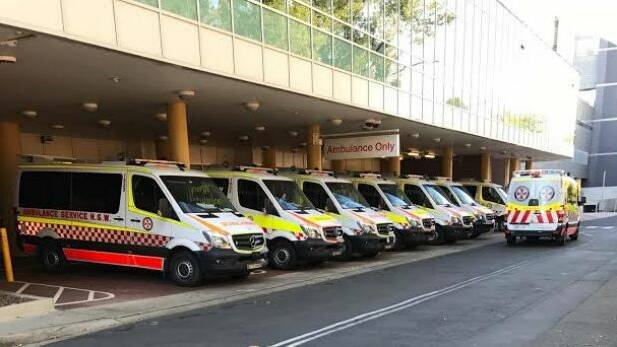 Ambulances wait at Liverpool Hospital after transporting patients on Tuesday. Photo: Supplied