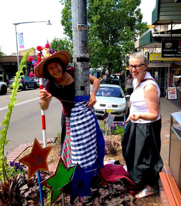 A stitch in time: Kate Paterson sews an outfit on to a light pole in Katoomba Street, helped by Lynne Curan.