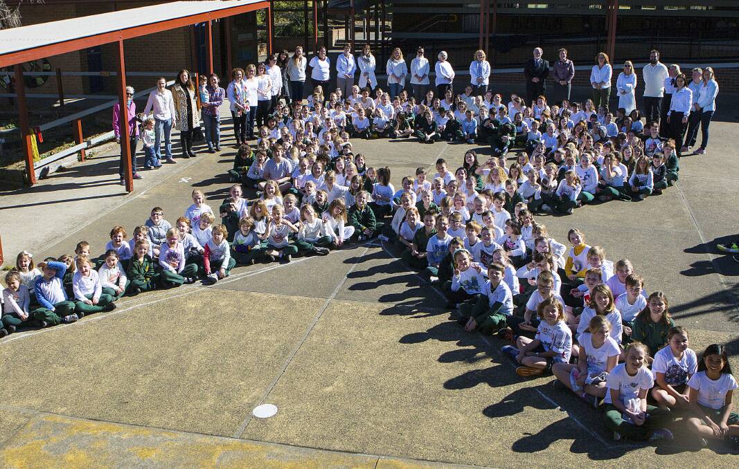 Students, staff and community members at Lawson Public make a white ribbon in support of respectful relationships.