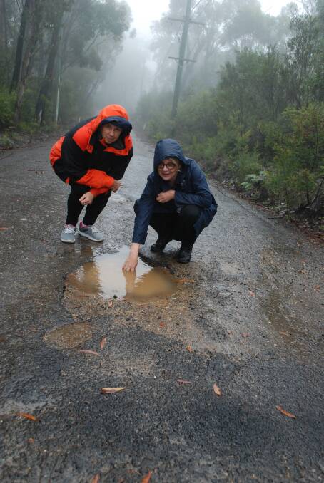 In a puddle: Many drivers have to veer on the other side of the road to avoid the potholes.