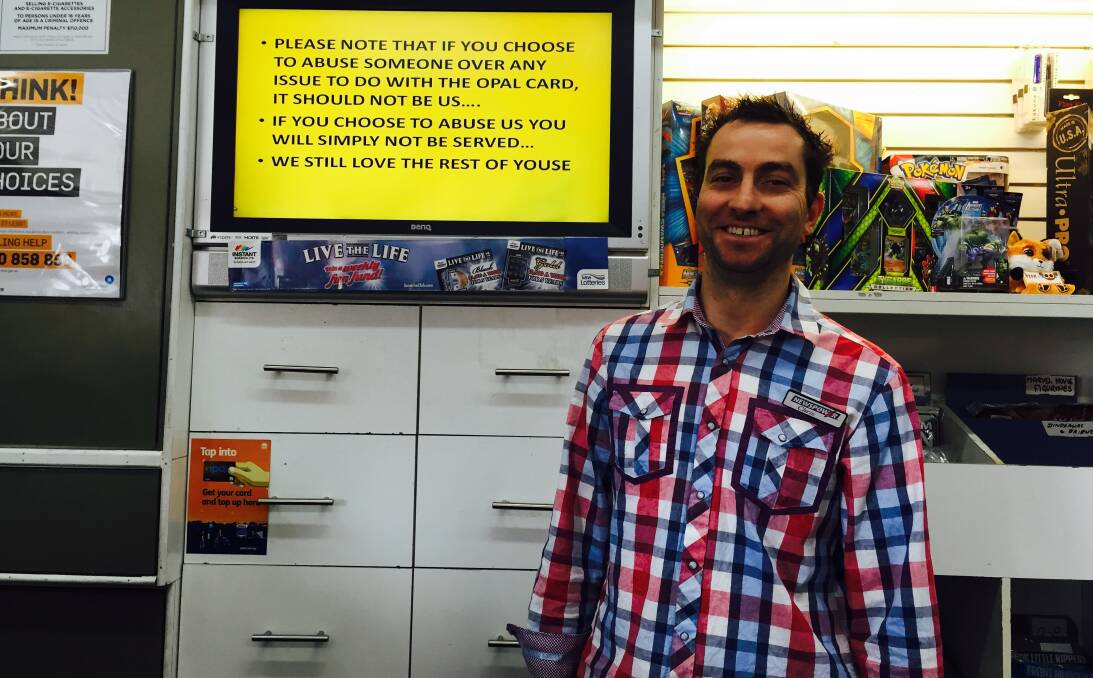 It's not our fault: Chris Johnson from Springwood Newsagency with the sign asking customers not to vent their Opal frustrations out on staff.