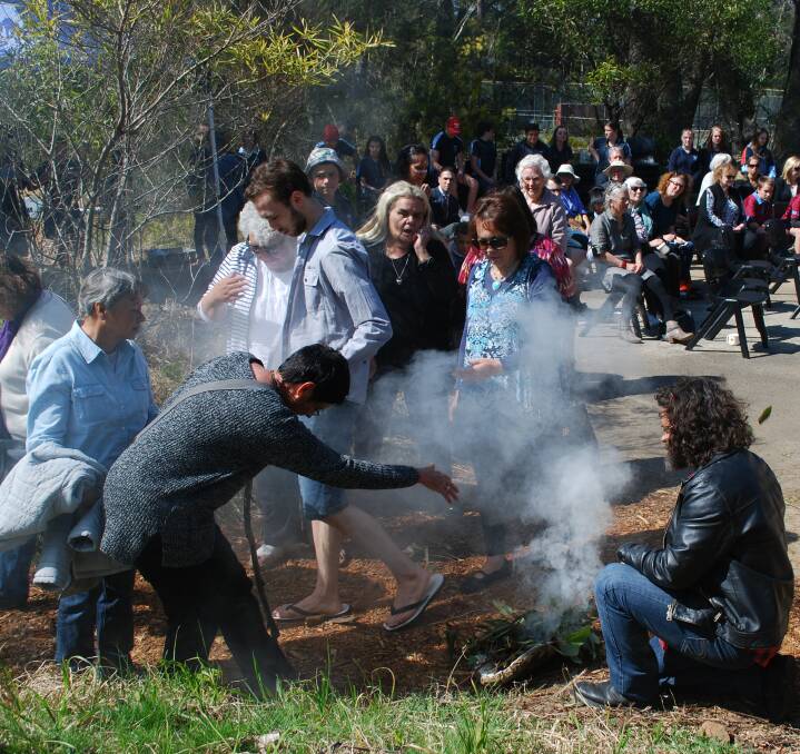 Embracing the smoke: Aboriginal elders are cleansed in a smoking ceremony on their way into Birriban at Katoomba High School.