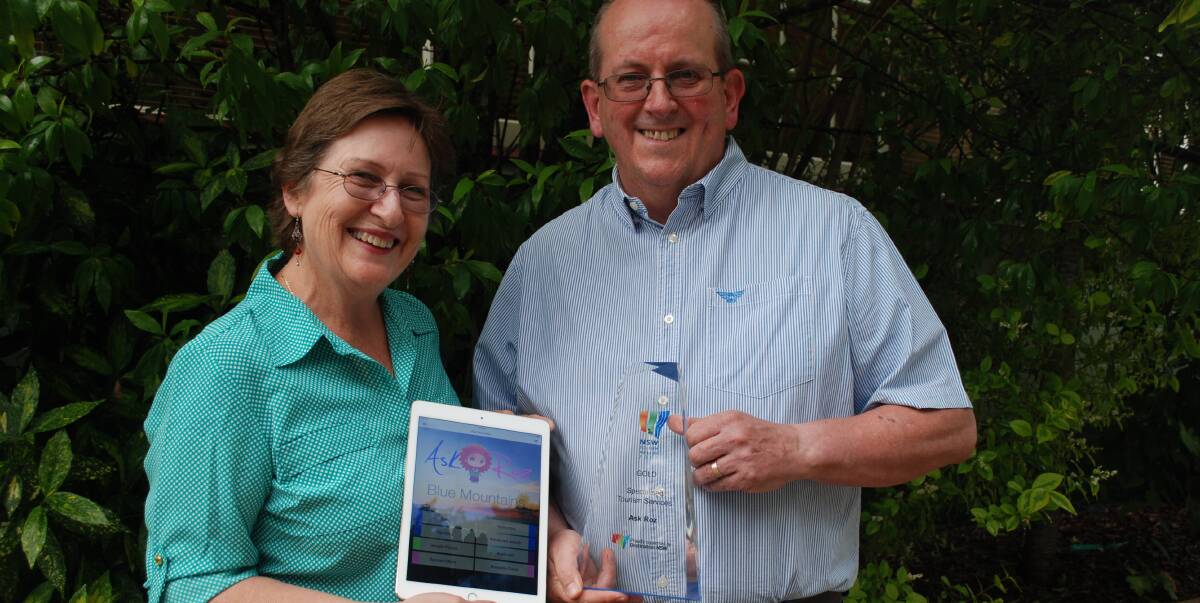 Ask Roz: Lawson couple Roslyn and Graham Reibelt with the Ask Roz home screen and their gold NSW Tourism award for specialised tourism services.