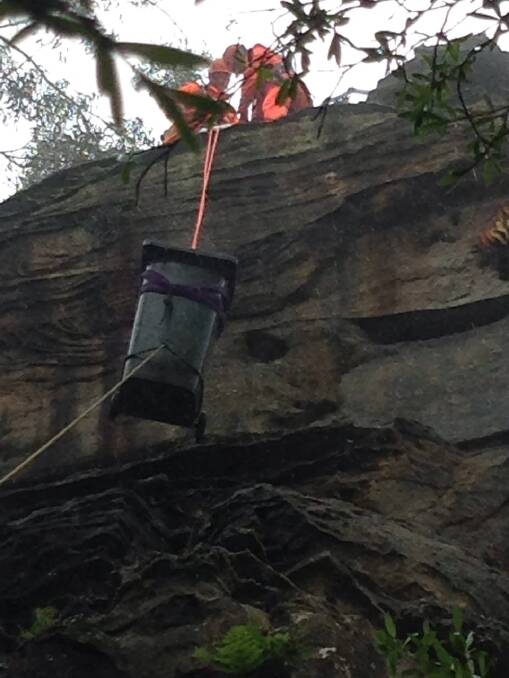 Going up: A half-filled wheelie bin is brought up from the valley at Spooners Lookout by SES volunteers.