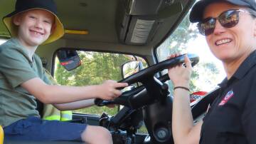 One of the special treats for children at Australia Day in Glenbrook is the appearance of staff and engine from Glenbrook 301 Fire Rescue station. Officer Wendy Hemmons instructs six-year-old Ryan Orr on the engine's operation in 2023. Picture supplied