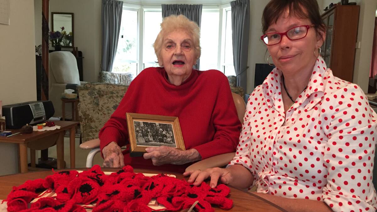Patricia Williams and Danette Rowse with some of the poppies they have made. Mrs Williams is holding a photo of her parents wedding.