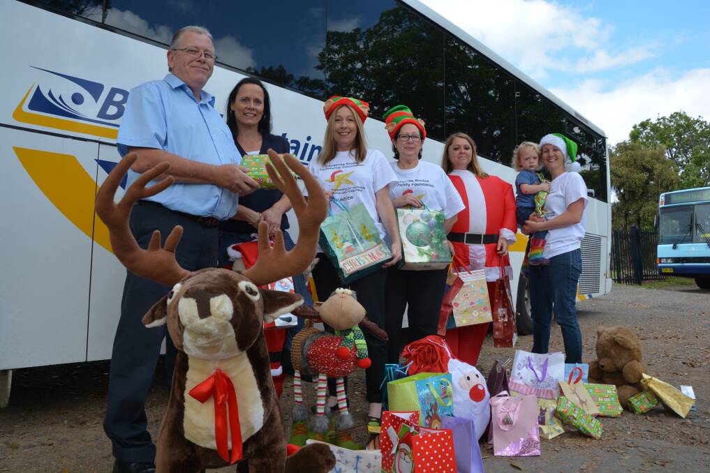 The gift of giving: Blue Mountains Transit's Russel Felstead and Samantha Rutland, with Christmas Smiles volunteers Sara Baxter, Kath Sargent, Sarah Cuzner and Marissa McGregor with Byron, 2.