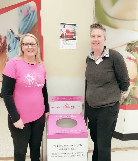 Share the Dignity volunteer Karen Brooker with Coles Winnalee manager Bec Clayton and the donation box at Coles Winmalee.