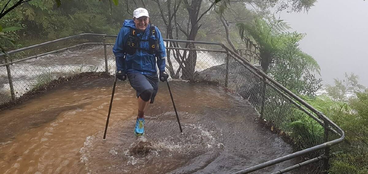 Paralympian Michael Milton training in the Blue Mountains in March when there was torrential rain. He's competing in Saturday's UTA 50km race on crutches.