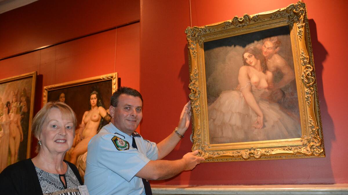 Temporary home: Norman Lindsay Gallery director Amanda Trevillion and Blue Mountains Police local area command Superintendent Darryl Jobson, hang Woman and Satyr on the gallery wall.