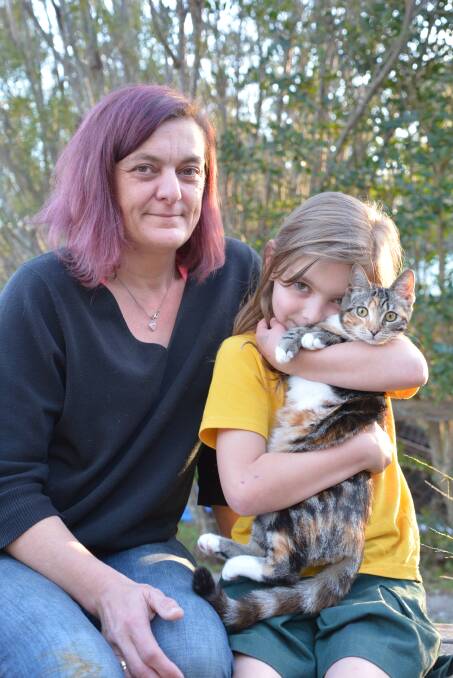 Sylvia Szabo and Poppymya Newman, 8, with cat Milo.