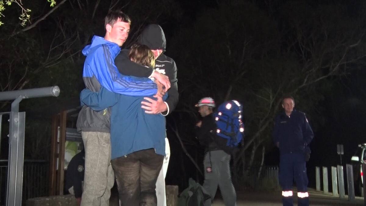 Reunited: Comforting the bushwalker who got lost in the national park at Wentworth Falls. Photo: Top Notch Video 