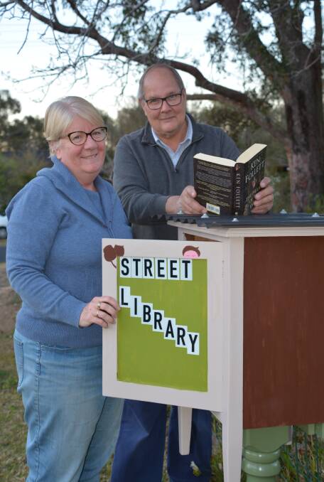 Connecting the neighbourhood: Anne and Russell Griffiths with their little street library in Springwood.