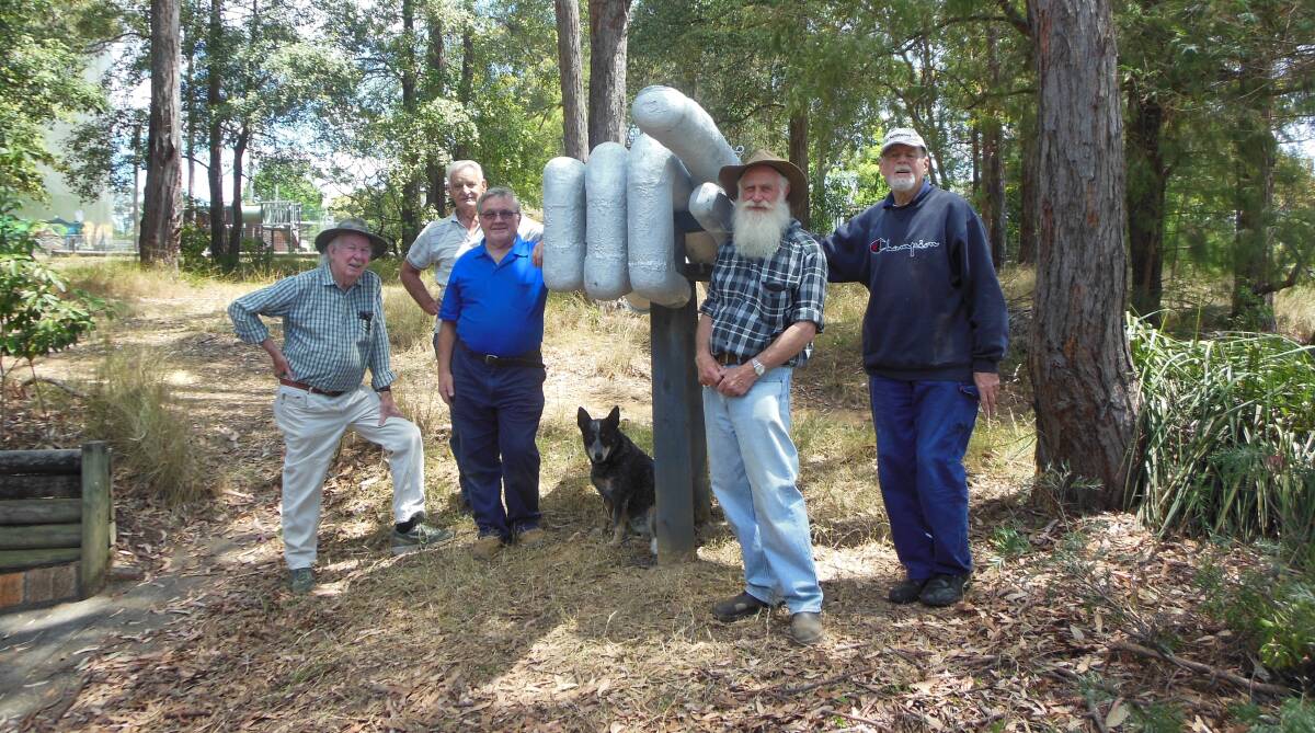 Work of art: Some of the Blue Mountains Woodturners who created the giant hand - Mike Boyle, Klaus Pohl, Dave Roberts, John Krook and Bill Wooldridge, with dog Tiggy.