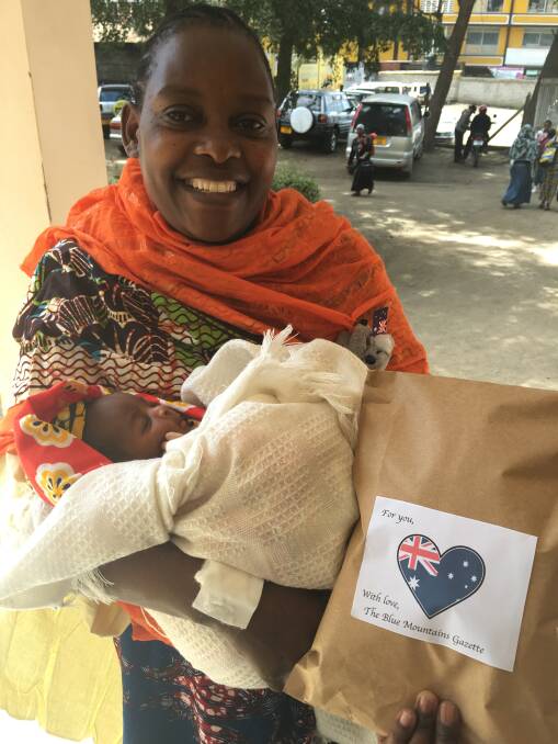 All smiles: Tanzanian mother Aisha with her fifth baby and one of the care packs.