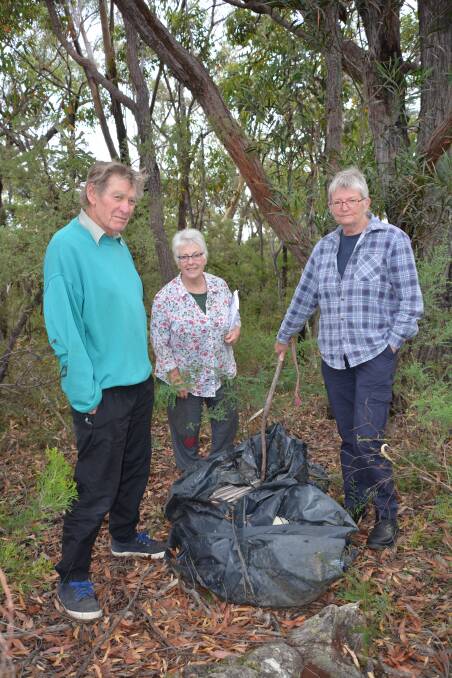 Still waiting: Dave Hegarty, Jan Cave and Leta van der Wal with what they believe is asbestos material. They first contacted the NPWS for removal of it 15 months ago.
