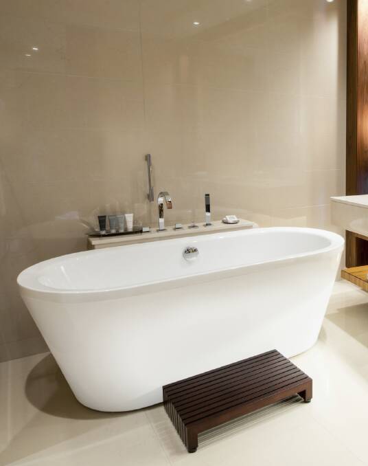 Resort luxury: Freestanding baths are a trendy way to update. Team it with a wall hung toilet, decorative lighting and a trendy sink basin for some resort styling.
