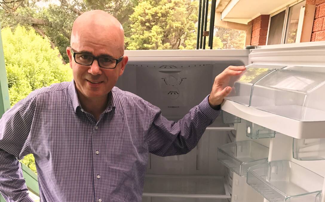 Mayor Mark Greenhill prepares an unused second fridge for Fridge Buyback to save money and reduce greenhouse gases.