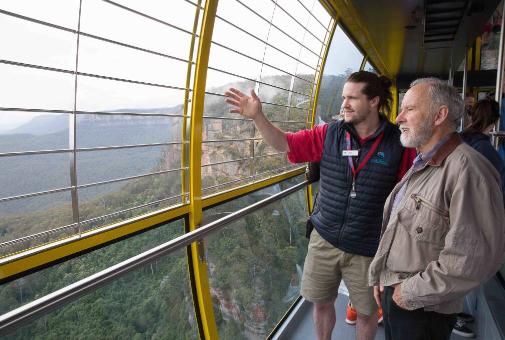 Scenic World staff member Peter Schefe, from Blackheath, guides people on a ride in the new Skyway.