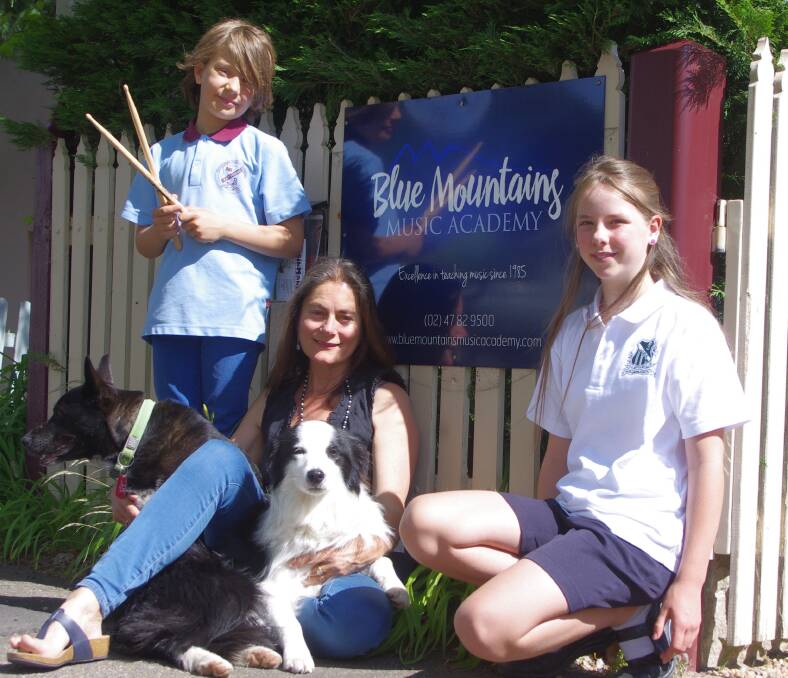 Love of music: Bryn Wegner, Lily Sepetauc with Blue Mountains Music Academy director Tracey Yarad and dogs Billie Rae and Music.