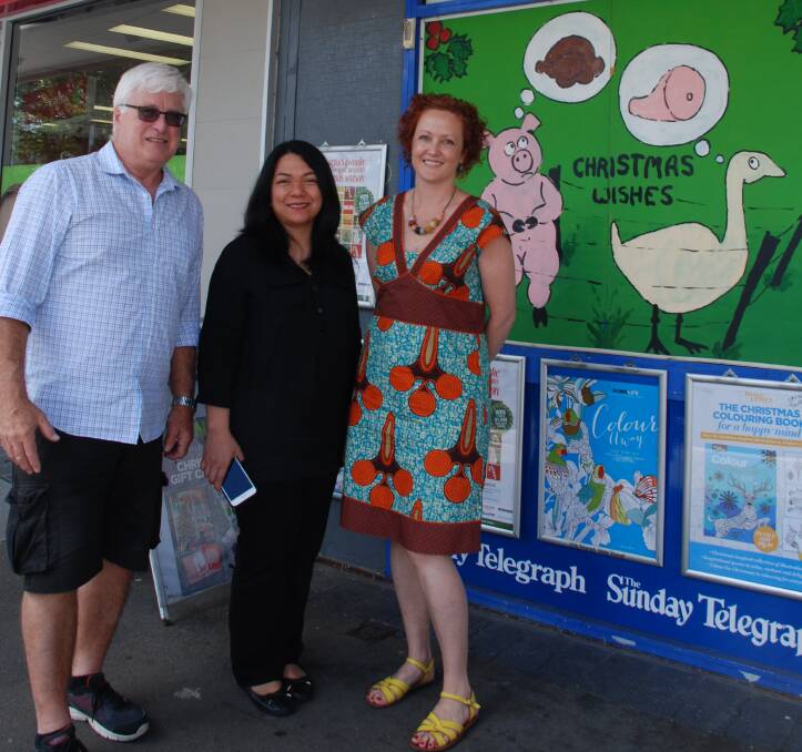 Festive: David Moss of Springwood Newsagency, Jenny Alanson of Colourart Springwood and Michelle Brown of Arabesque beside the newsagency's Christmas window.
