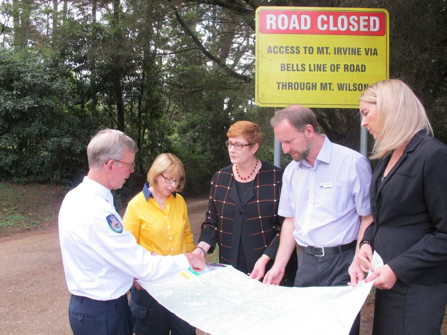 Liberal Senator for Western Sydney, Marise Payne (centre), examines a map of the area for a potential escape route with Mt Wilson/Mt Irvine Rural Fire Service president and deputy captain, David Howell; Mt Wilson/Mt Irvine RFS Brigade executive, Elizabeth Montano and Hawkesbury Councillors Nathan Zamprogno and Sarah Richards.