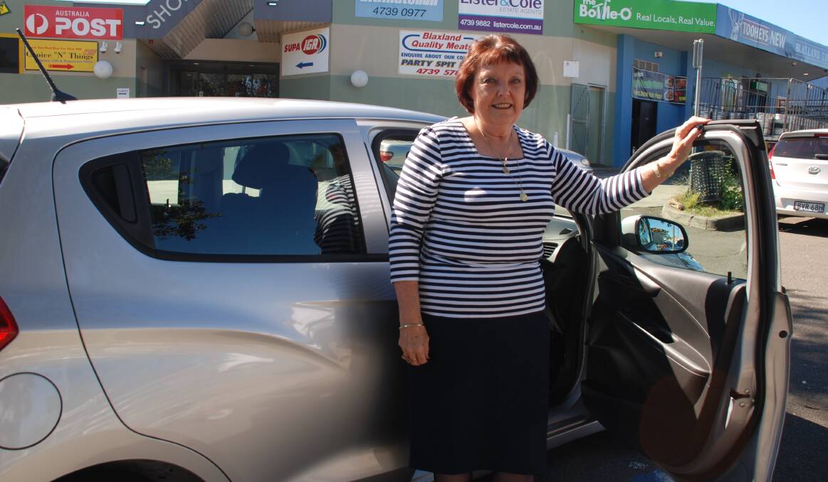 Blaxland resident Margaret Goodwin with the new Holden Spark she won in an IGA competition.