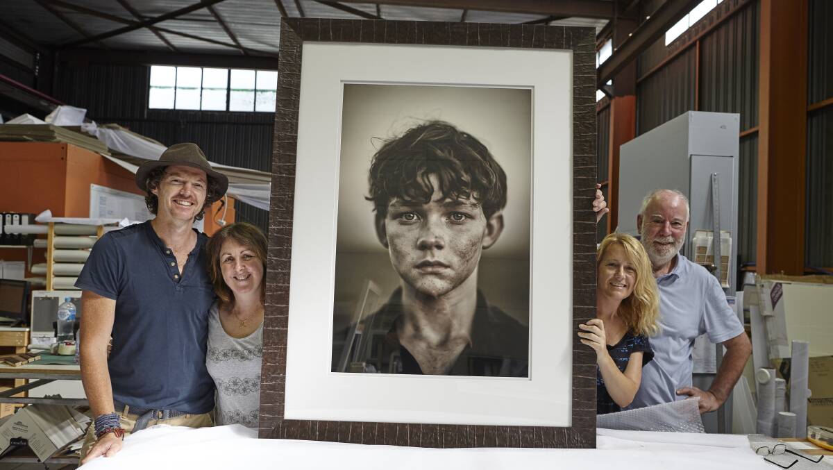 Springwood photographer David Darcy (left) and staff from Created For Life Printing and Framing with his portrait of actor Levi Miller.