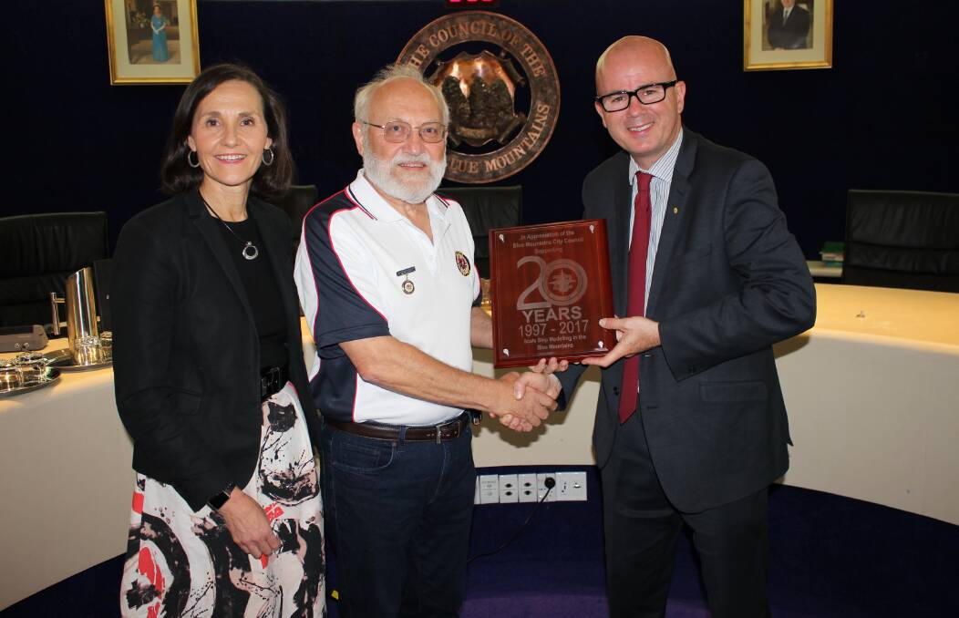 Task Force 72 president Tony Page presents Blue Mountains Councillor Romola Hollywood and Mayor Mark Greenhill with a plaque commemorating 20 years of scale ship modelling in the Blue Mountains.