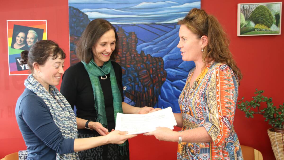 Time for a ban: Nina Gallo and Cr Romola Hollywood present Trish Doyle, MP,  with signatures on the Ban the Bag Blue Mountains petition at Ms Doyle’s electorate office in Springwood.