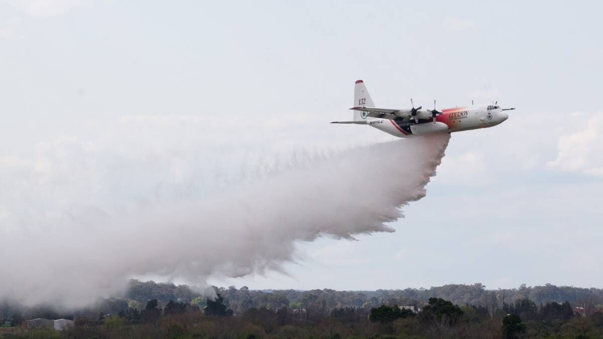 Thor drops a load adjacent to Richmond RAAF Base as part of a display on Thursday, September 8. The Large Air Tanker ‘Thor’ will remain in NSW into the new year to assist firefighters on the ground. Photo: Geoff Jones