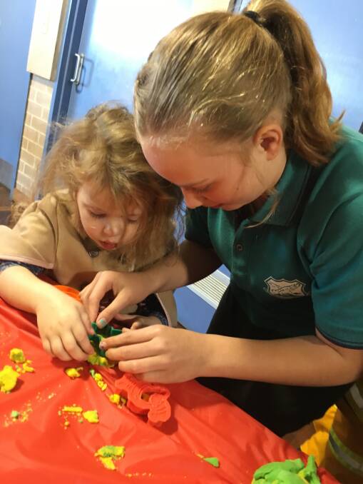There's always time for playdough: Edie Greenhill gets a helping hand from Lucinda Boreham.