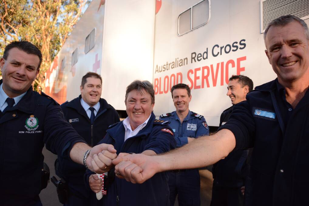 Blue Mountains Police commander superintendent Darryl Jobson, Inspector Michelle Lee from Springwood Ambulance Station and Springwood Fire Station Platoon D station officer Ian Sargent roll up their sleeves in support of the Australian Red Cross Blood Service's Red 25 winter campaign. Behind them are Sergeant Michael Magill and Springwood firefighters Mark Lutherburrow and Rafael Olmo.