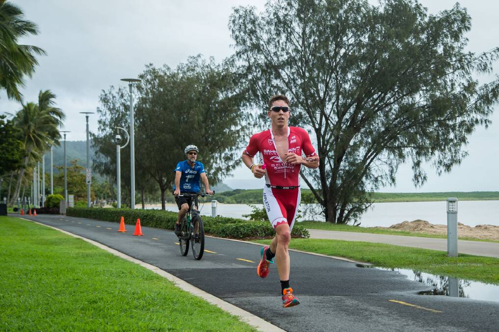 Speed to burn: An official watches Sam Appleton increase his gap over Craig Alexander in the final stages of the Ironman 70.3 race in Cairns. Photo: Korupt Vision/ Ironman Asia-Pacific.