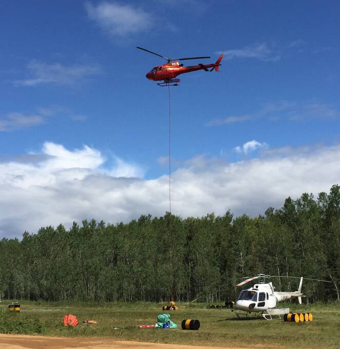 A helicopter pilot prepares to fill another load of water to drop on a huge wildfire burning in Puntzi Lake in north-western Canada. A team of 102 Australian firefighters, including Lindsay West, are currently in Canada providing assistance.