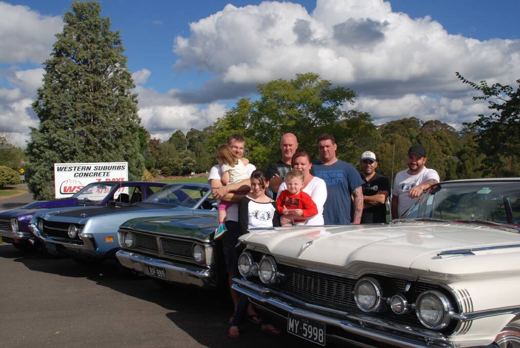 Mark and Isla Vanhooft, Wayne Beard, Matthew Magri, Peter Nassif, Michael Burke, and front, Allana Burke with Charlotte and Chance, with some of the cars on show at Sunday's Cameron Burke Memorial Day.