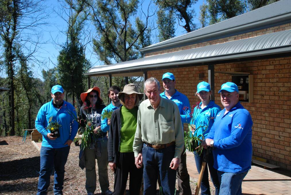 Some of the Lend Lease volunteers Francis Houlihan, Winmalee Neighbourhood Centre manager Morna Colbran, Ben Whitehouse, Ross Barker, Eimear Kelly and Matt Moon, last week replanted Pam and Lloyd Chamberlain's garden destroyed during last year's October bushfires.