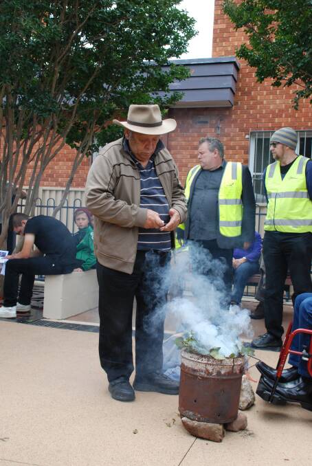 Aboriginal Elder, Uncle Wesley Marne, performs the smoking ceremony at the memorial event on Saturday.