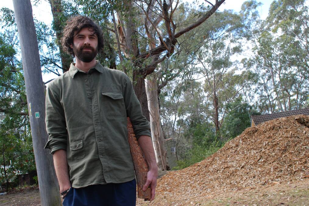 Ecologist and local resident Eli Bendall in front of a pile of woodchips at Mt Riverview.