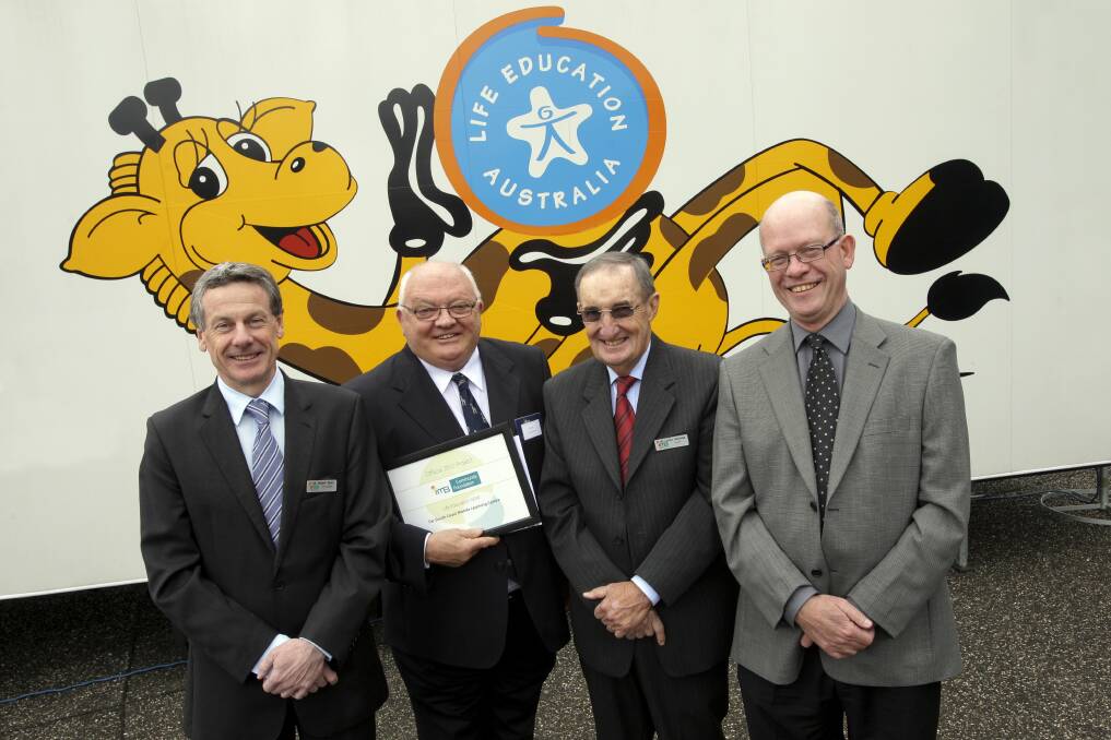 Jay Bacik CEO of Life Education NSW (holding certificate) at an event in Newcastle. He says there is no need to be concerned by Life Education Blue Mountains losing its charity status as the group is no longer running. Fairfax Media file photo