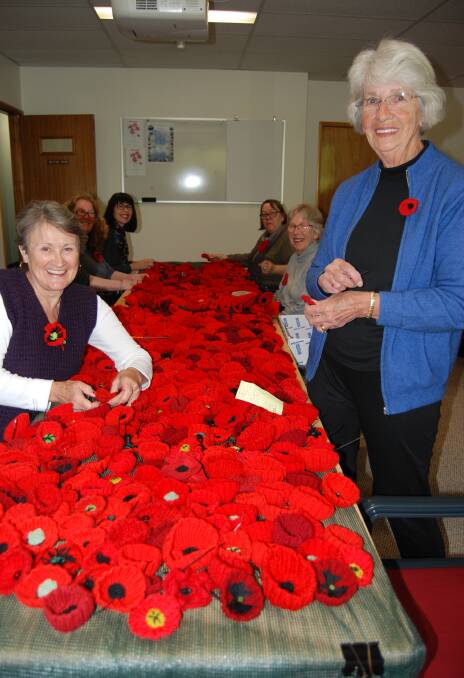 Robyn Zikan, Lynne Mason, Amanda Anicic, Helen Armand, Liz Cunningham and Paula Savage help attach some of the 12,000 poppies to shade cloth which will be draped in Springwood and Katoomba hospitals to mark the centenary of the Gallipoli campaign. 