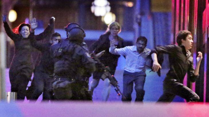 Hostages flee the Lindt Cafe: the role of social media communications during the siege will come under coronial scrutiny. Photo: Andrew Meares