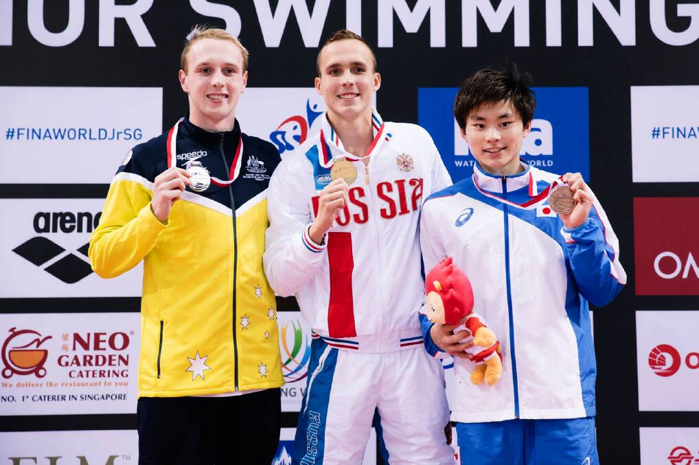 Springwood's Matthew Wilson (left) on the podium at the World Junior Swimming Championships in Singapore last month with the silver medal he won in the 200m breastrstroke.
