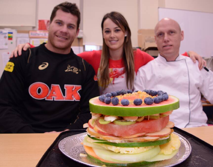 What a feast: Panthers player Kevin Kingston, Year 2 teacher Haylie Excell and Panthers head chef Tim Wesley with the amazing "Fruit Ninja" sandwich created by the school's support class.