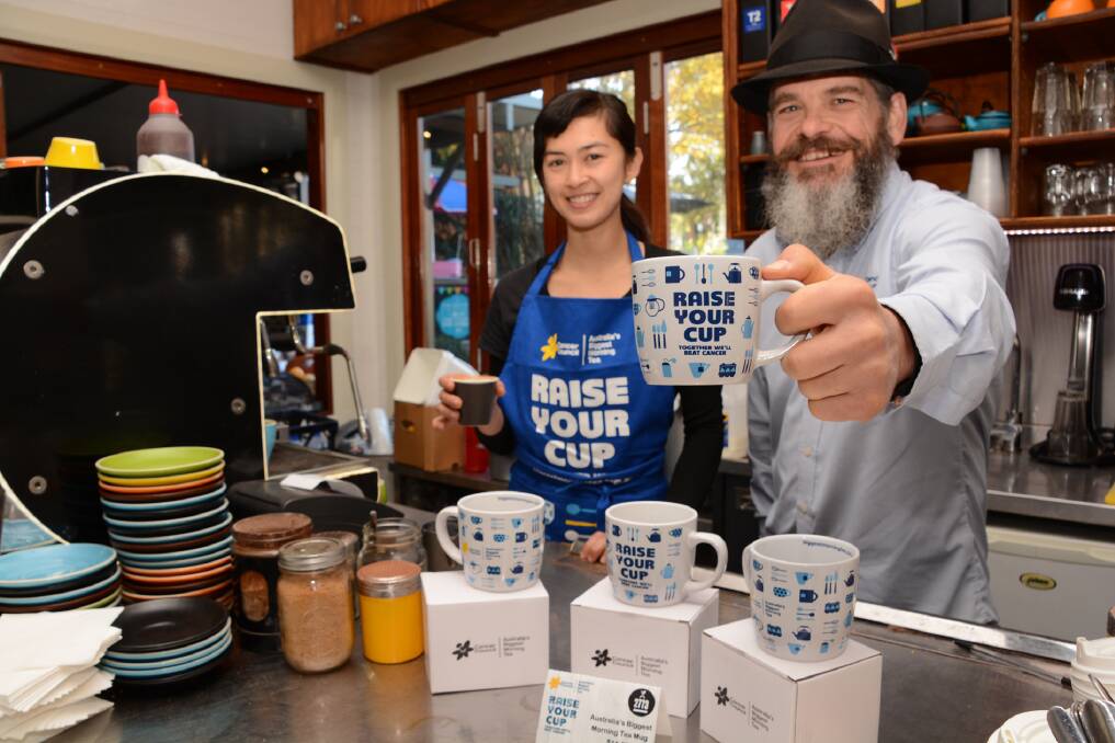 Cheers: Barista Leah Dempsey from 2773 Cafe in Glenbrook and Cancer Council NSW community programs co-ordinator for Blue Mountains, Rodney Titovs, show off the new campaign mugs for Australia's Biggest Morning Tea, on now until the end of June. Photo: Shane Desiatnik.