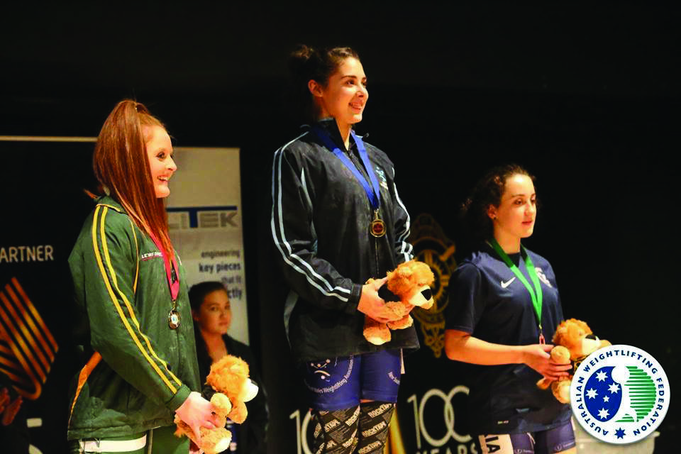 Yasmin Carter (centre) receives her gold medal at the 2015 AWF National Youth Championships in June.