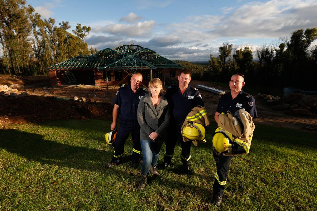 Bonnie Wilkinson whose house burnt down in Singles Ridge Road, Yellow Rock. She was rescued by senior firefighters Onur Ayyildiz, and Grant Quinlan. The firefighter on right, Wayne Norton was in charge of the fire truck. Photo: Peter Rae.